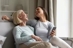 happy-elderly-mother-and-adult-daughter-using-smartphone-together