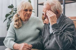 retired-woman-holding-hands-senior-husband-having-headache-625x417